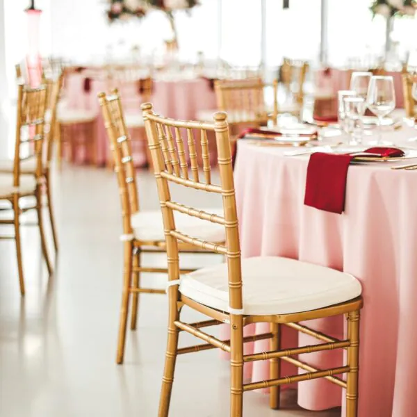 Svadobná výzdoba so zlatými stoličkami a svetloružovými obrusmi Elesko Galéria