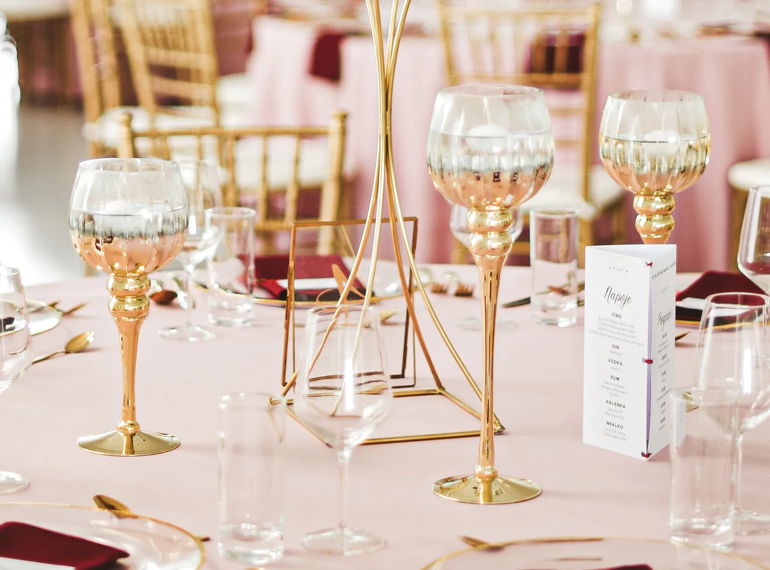 Svadobná výzdoba stola so zlatými stojanmi na sviečky