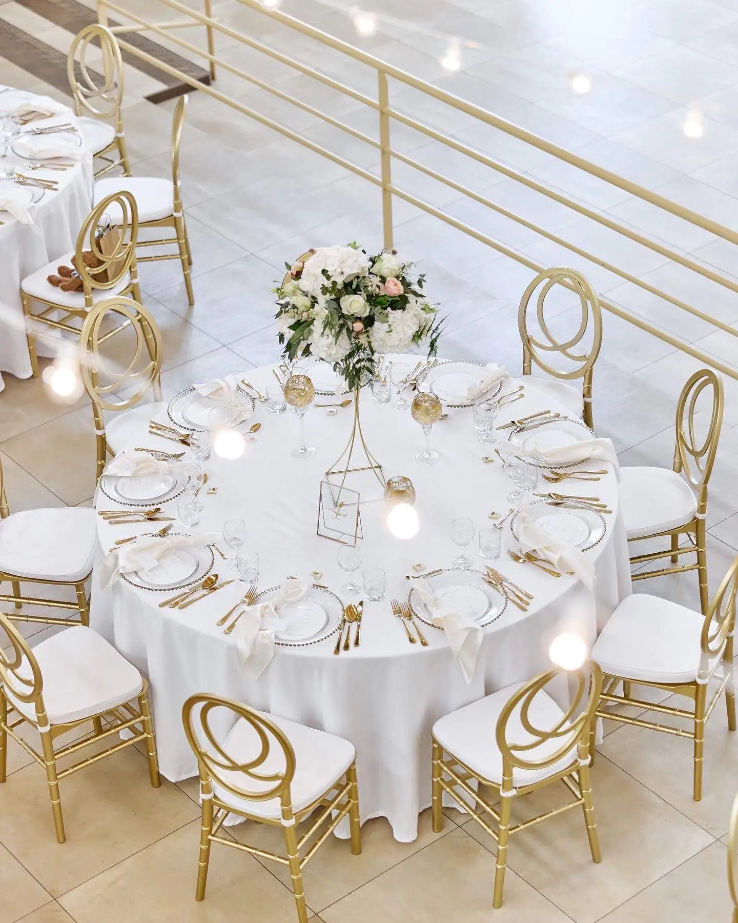 Svadobný stôl so zlatými stoličkami a bielym obrusom Šoporňa